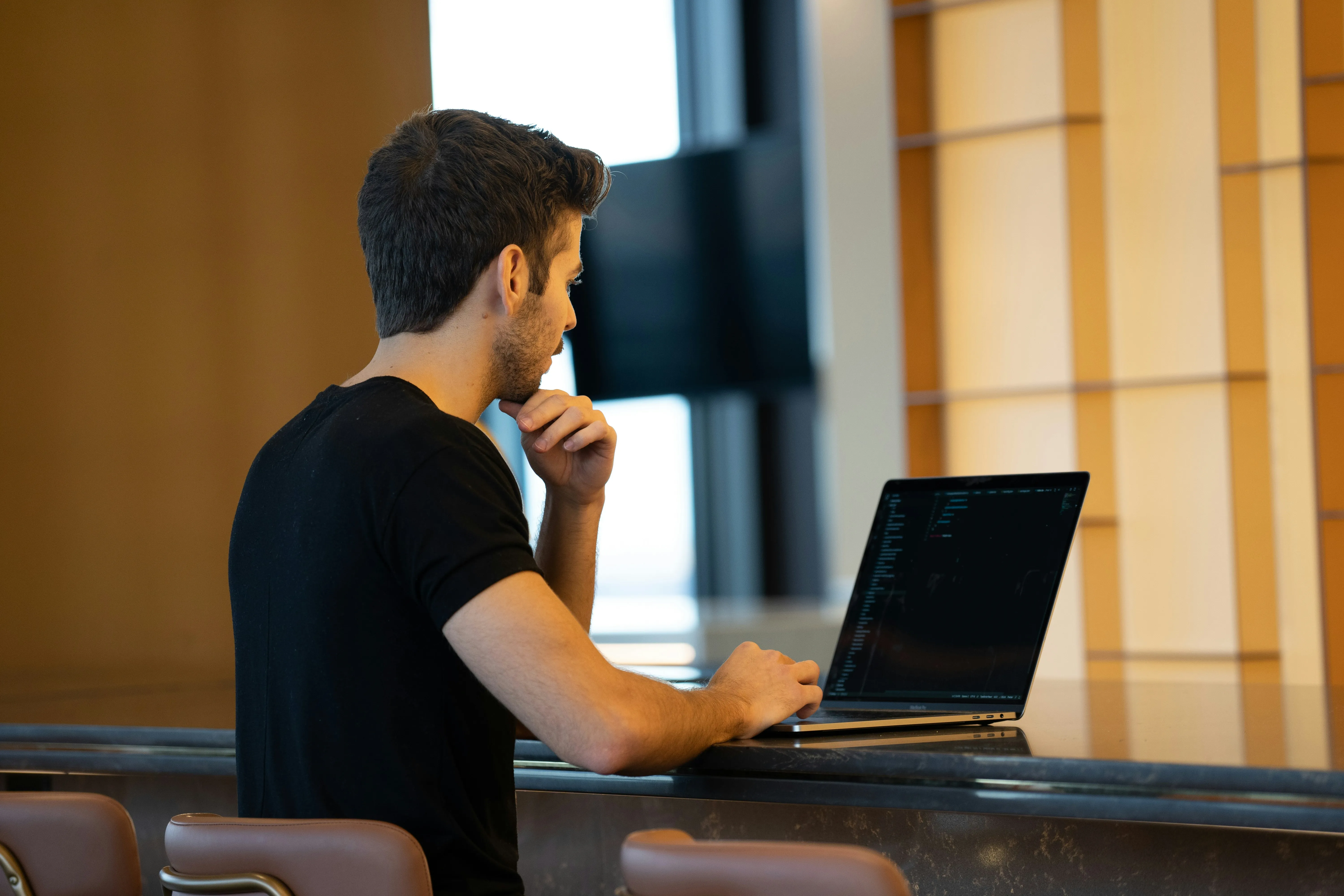 Mann arbeitet am Laptop und behält seine IT im Blick
